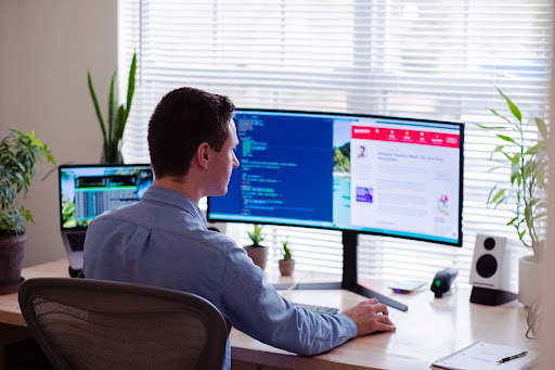 A man working in front of two monitors